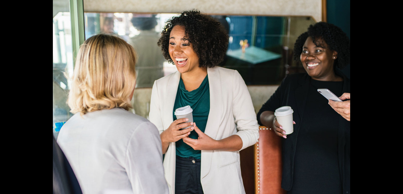 Black woman networking with collegues over coffee