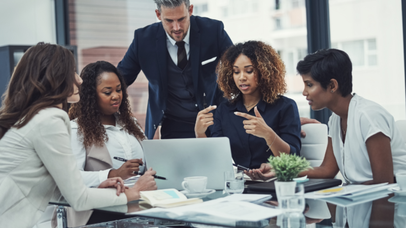 Black woman using impactful communication to lead a meeting in an office